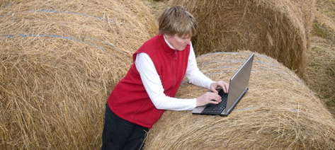 Kvinna med dator på höbal